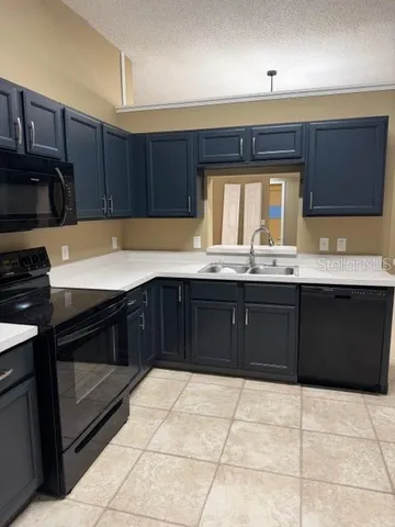 a view of an empty room with window and refrigerator