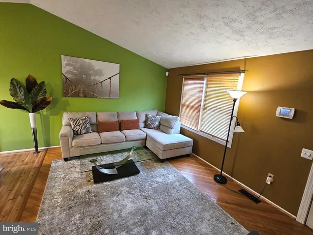 a living room with furniture and a air conditioner vent