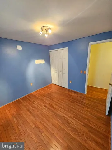 a view of a big room with wooden floor and windows