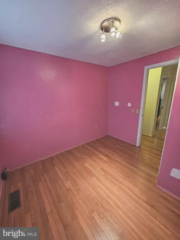 a view of empty room with a fireplace and wooden floor