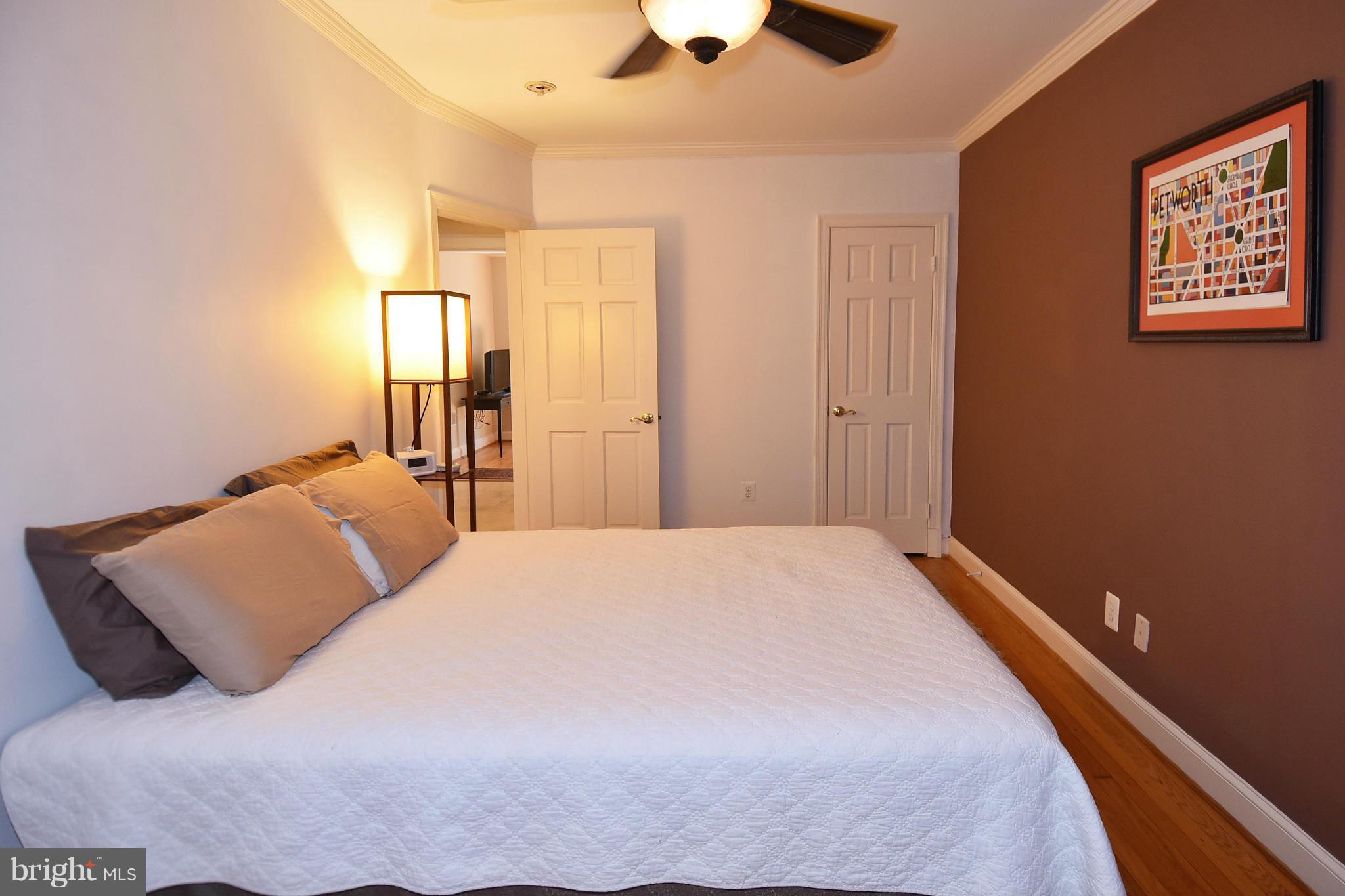 4010 Kansas Avenue Northwest, Unit 1 Washington, DC 20011 - Photo 11 of 28 a bedroom with a bed and a chandelier