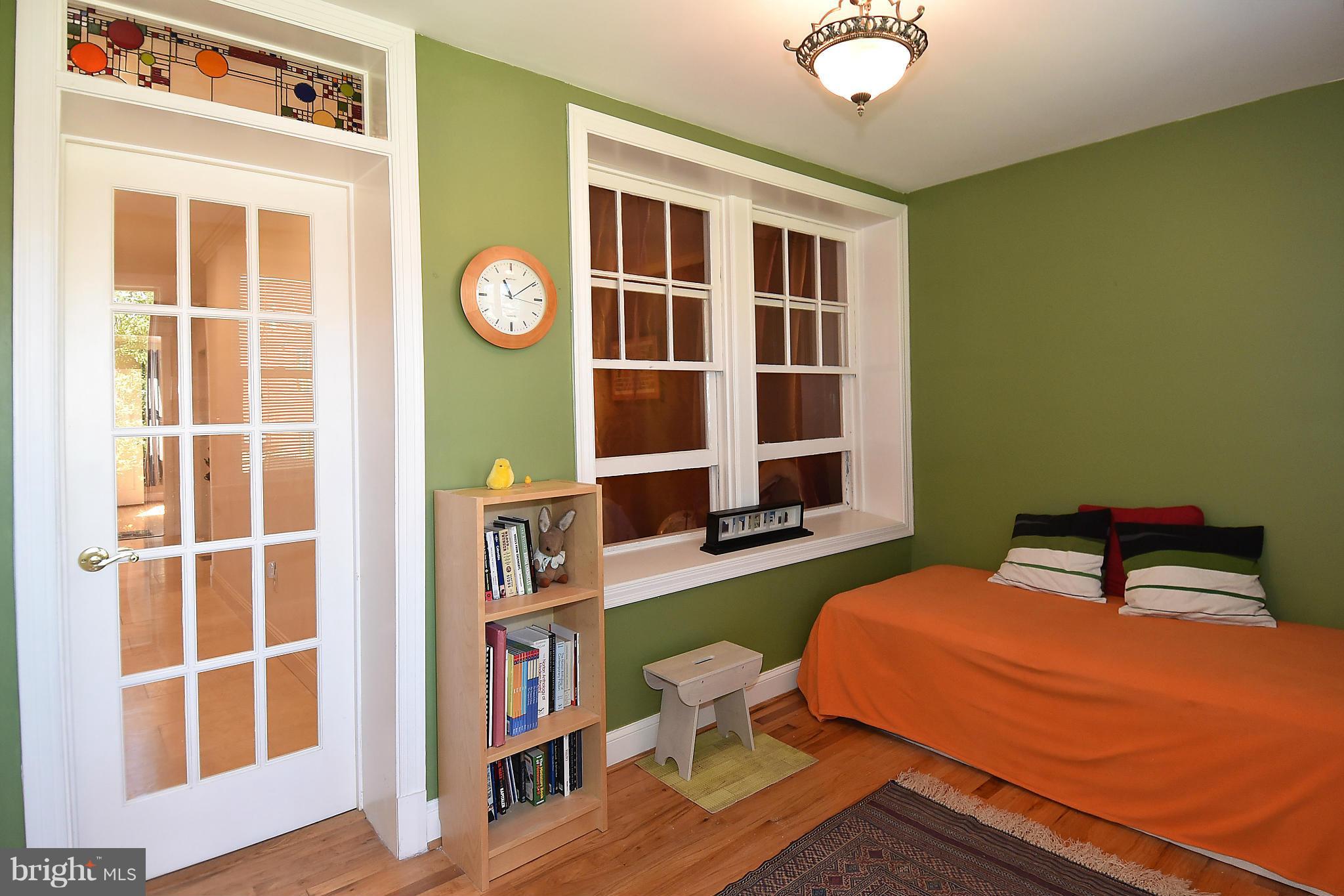 4010 Kansas Avenue Northwest, Unit 1 Washington, DC 20011 - Photo 14 of 28 a bedroom with a bed and a bookshelf