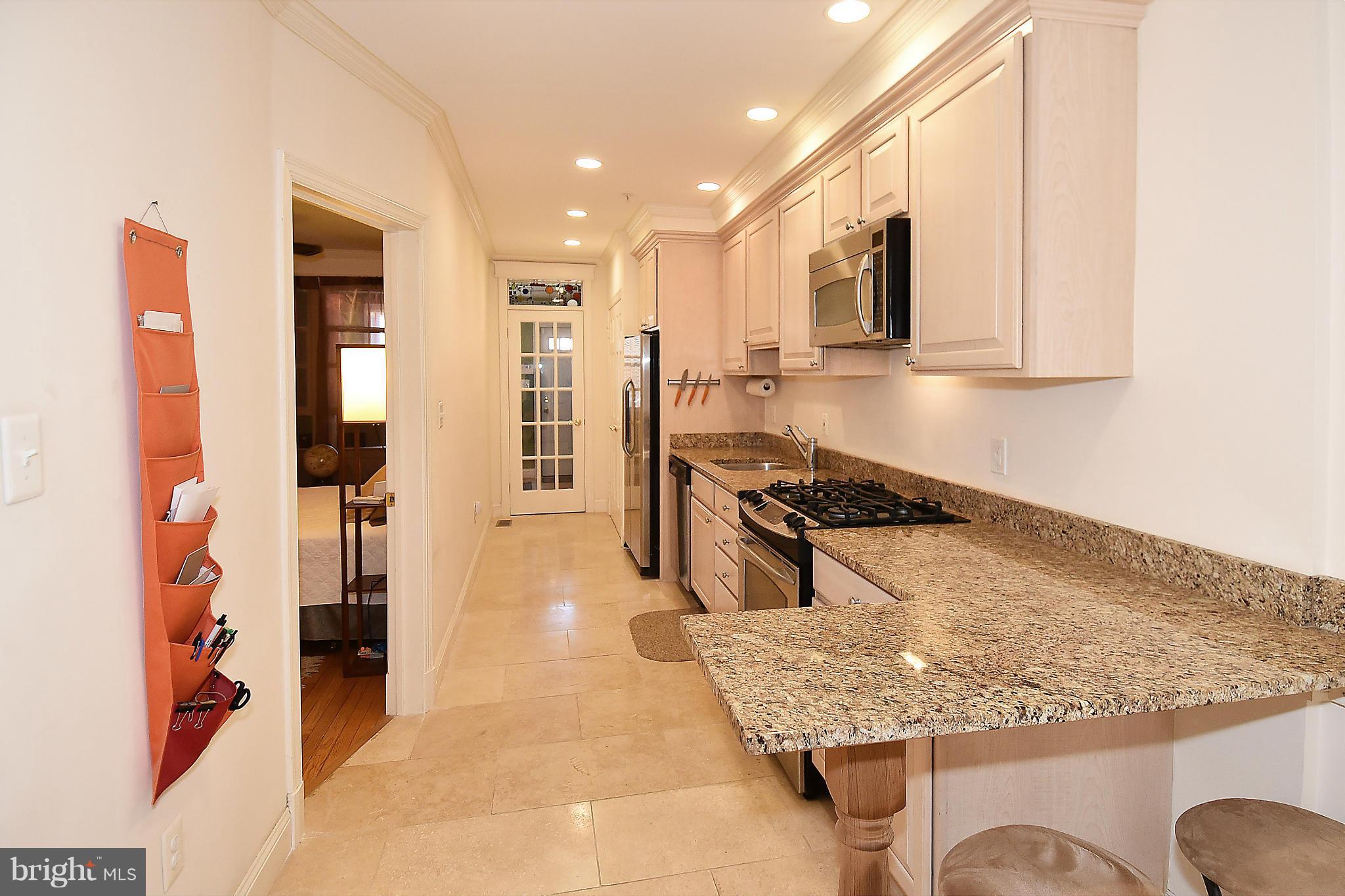 4010 Kansas Avenue Northwest, Unit 1 Washington, DC 20011 - Photo 6 of 28 a kitchen with stainless steel appliances granite countertop a stove oven and a refrigerator with white cabinets