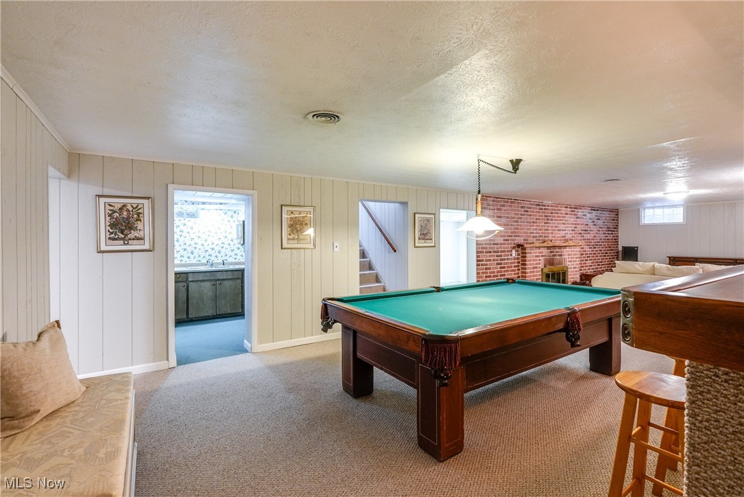 2488 Holgate Road Akron, OH 44313 - Photo 35 of 50 Expansive recreation room with a bar, wood burning fireplace, easy access to the exercise room, laundry room and second kitchen, office, and full bath.