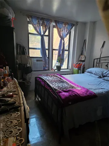 a bedroom with bed and a window