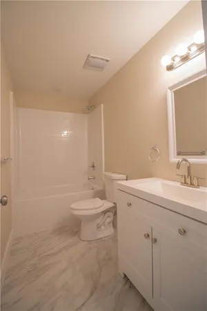 a bathroom with a toilet a sink a mirror and vanity