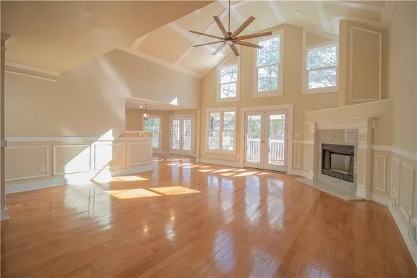 a view of an empty room with wooden floor and a fireplace