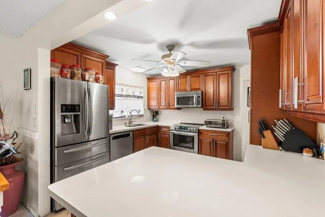 a kitchen with stainless steel appliances granite countertop a refrigerator stove top oven and sink