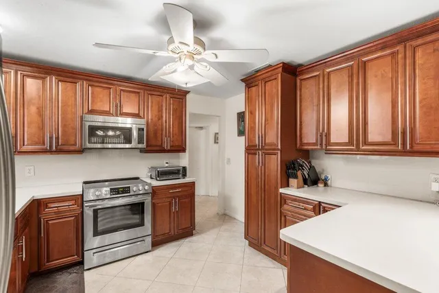 a kitchen with wooden cabinets and stainless steel appliances