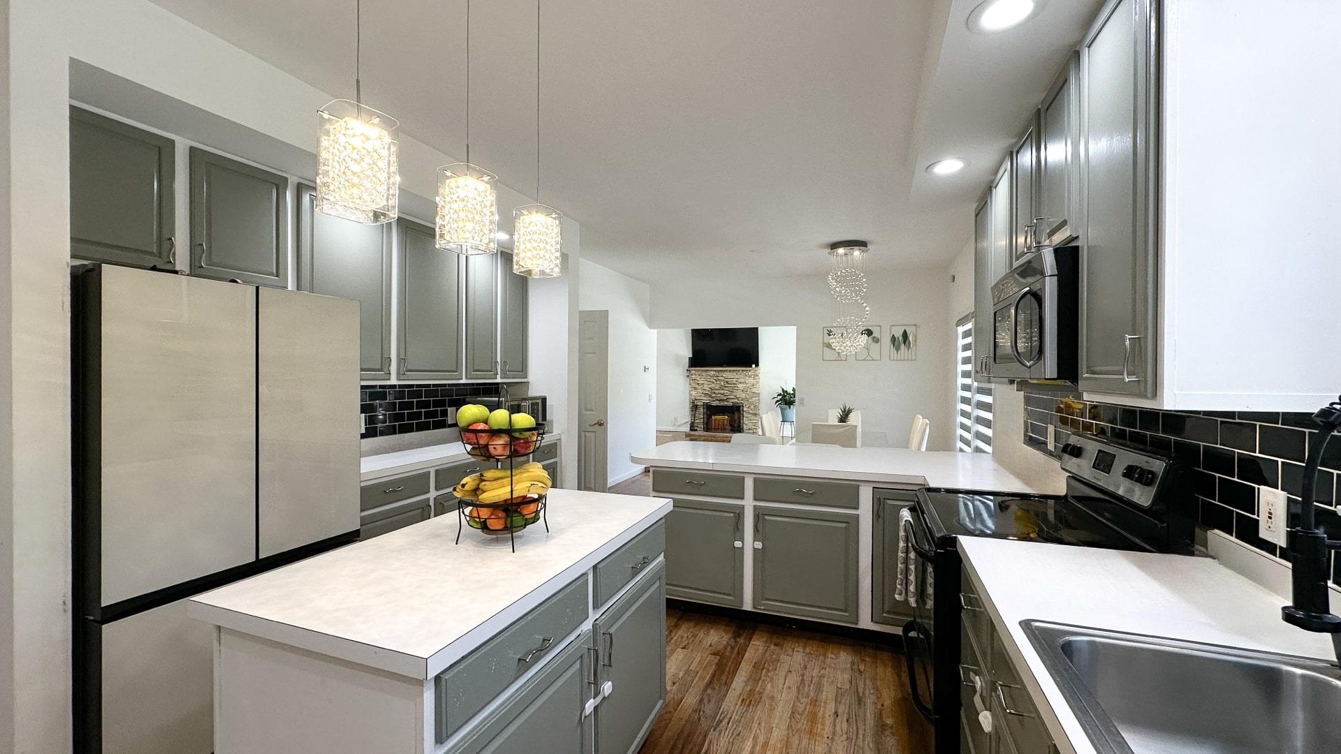 39 Washington Avenue East Hampton, NY 11937 - Photo 13 of 21 Kitchen featuring light countertops, appliances with stainless steel finishes, a sink, gray cabinetry, and backsplash