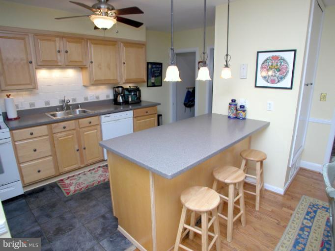 222 Gaywood Road Baltimore, MD 21212 - Photo 2 of 24 a kitchen with stainless steel appliances a table chairs and white cabinets