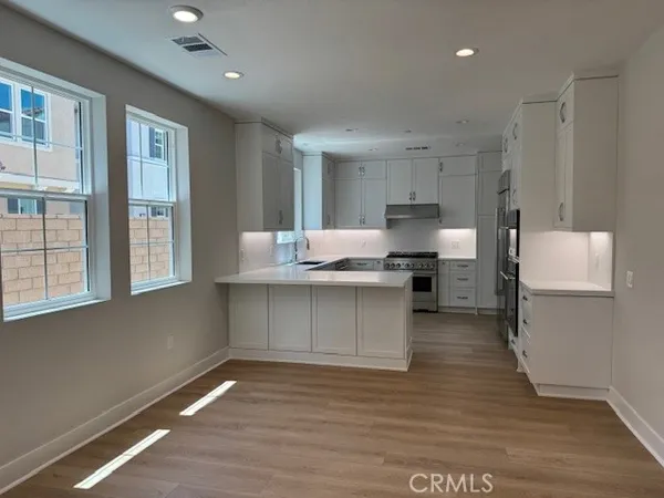 a kitchen with granite countertop white cabinets and stainless steel appliances