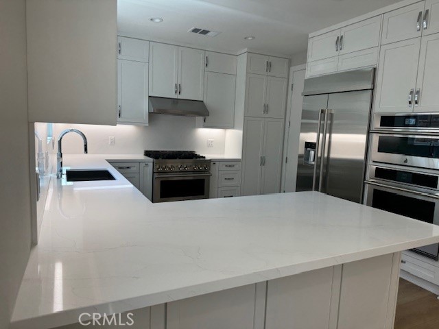 581 Patten Avenue Placentia, CA 92870 - Photo 5 of 23 a kitchen with stainless steel appliances a refrigerator a stove and white cabinets