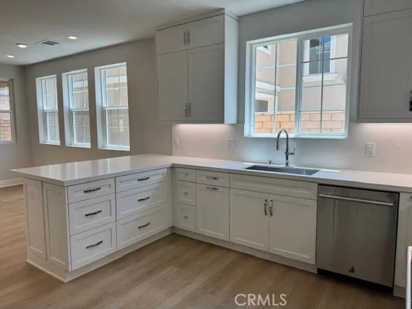 a kitchen with granite countertop white cabinets and a sink