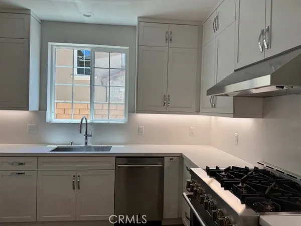 a kitchen with granite countertop a sink stove and cabinets