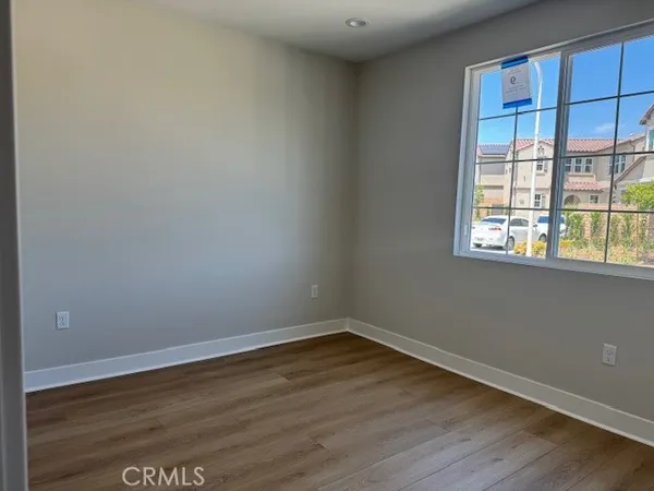 a view of a room that has wooden floor and cabinets