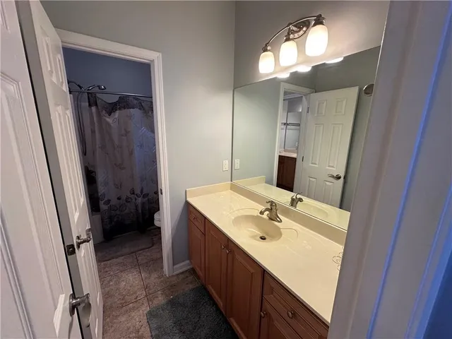 a bathroom with a sink a mirror a vanity and shower