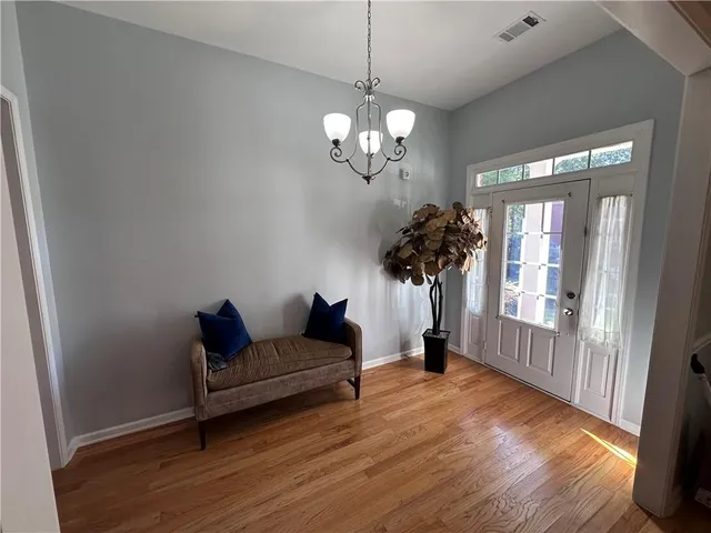 a living room with furniture a chandelier and a wooden floor