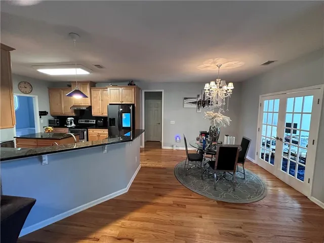 a view of a dining room with furniture a chandelier and wooden floor
