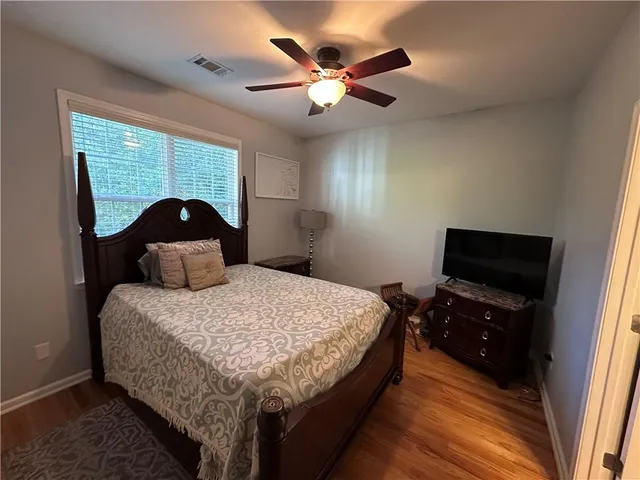 a bedroom with a bed and a flat tv screen on the dresser