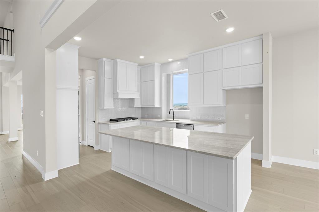 9916 Polo Pitch Lane Forney, TX 75126 - Photo 12 of 27 a kitchen with kitchen island a sink appliances and cabinets