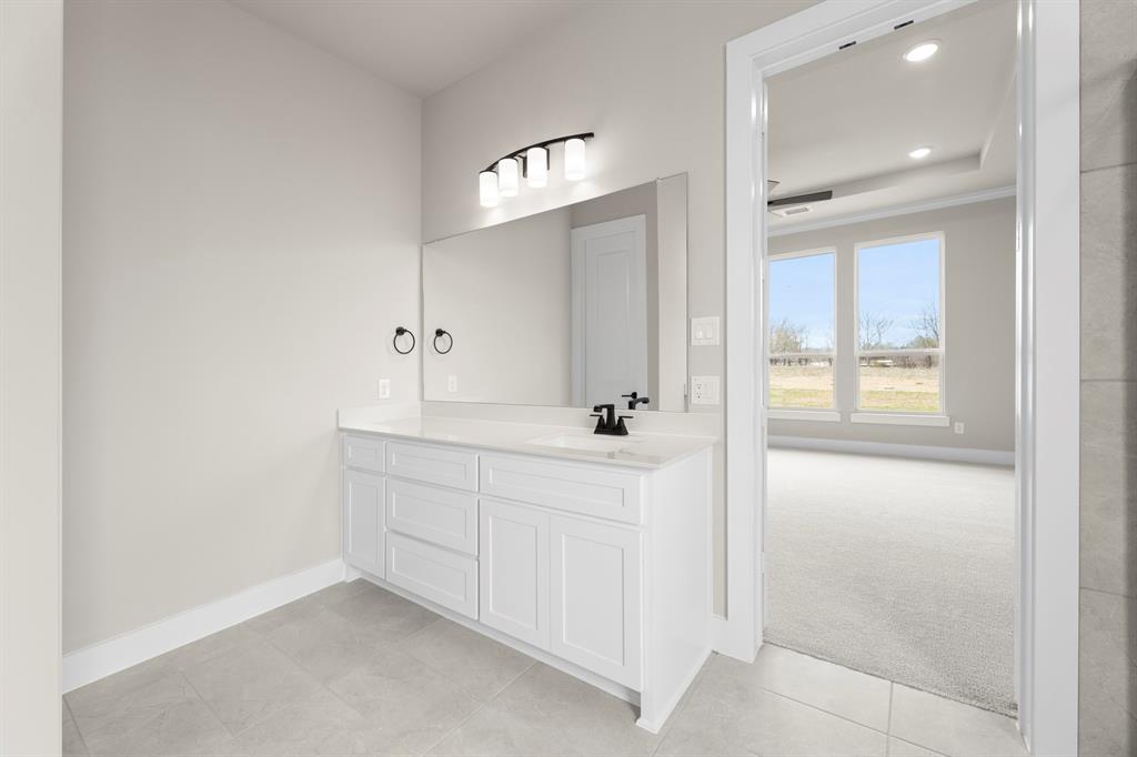 9916 Polo Pitch Lane Forney, TX 75126 - Photo 18 of 27 a bathroom with a double vanity sink a vanity and a mirror