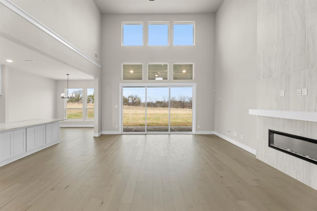 9916 Polo Pitch Lane Forney, TX 75126 - Photo 8 of 27 an empty room with wooden floor and windows