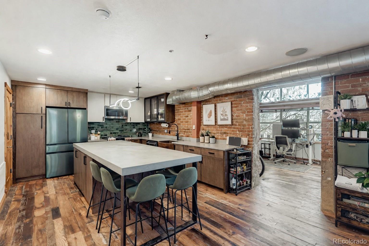 3033 Blake Street, Unit 109 Denver, CO 80205 - Photo 11 of 43 a kitchen with stainless steel appliances a dining table chairs stove and refrigerator