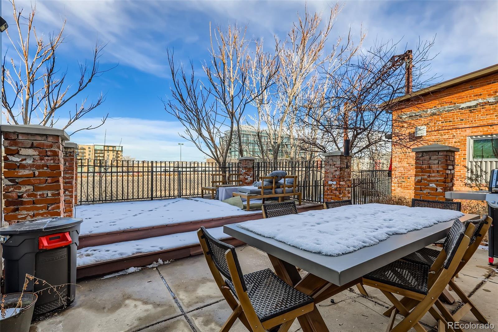 3033 Blake Street, Unit 109 Denver, CO 80205 - Photo 39 of 43 a backyard of a house with barbeque oven table and chairs