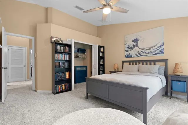 a spacious bedroom with a bed and a chandelier