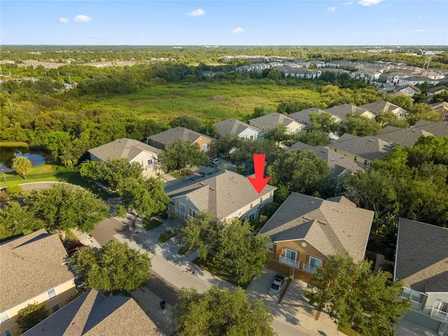 an aerial view of residential houses with outdoor space and lake view