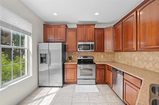 a kitchen with stainless steel appliances granite countertop a refrigerator and a sink