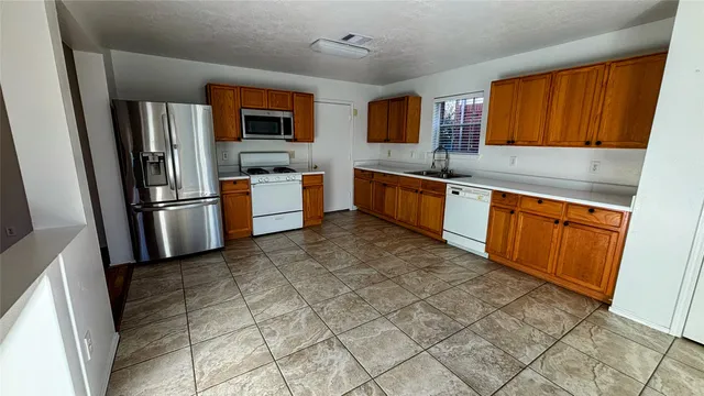 a kitchen with stainless steel appliances granite countertop a refrigerator sink and microwave
