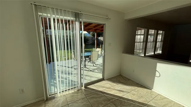 a view of a backyard with table and chairs under an umbrella
