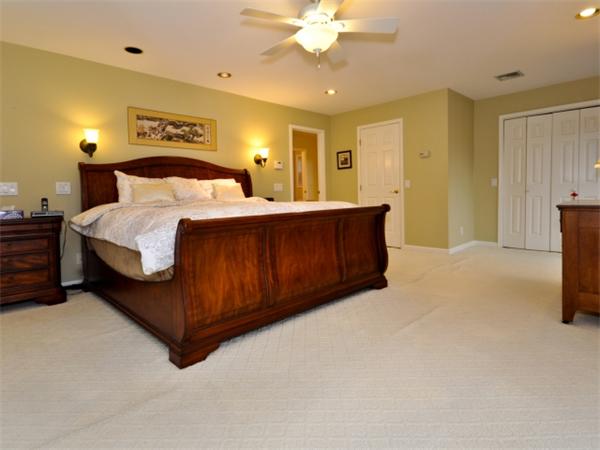 75 Ridgeway Avenue Needham, MA 02492 - Photo 19 of 22 a spacious bedroom with a bed and a chandelier