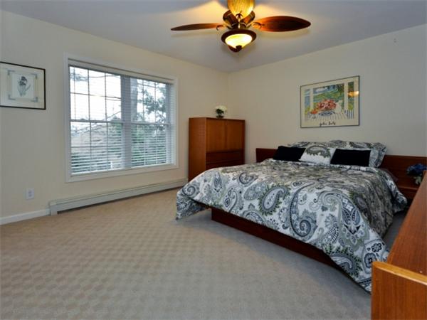 75 Ridgeway Avenue Needham, MA 02492 - Photo 20 of 22 a bedroom with a bed and a chandelier