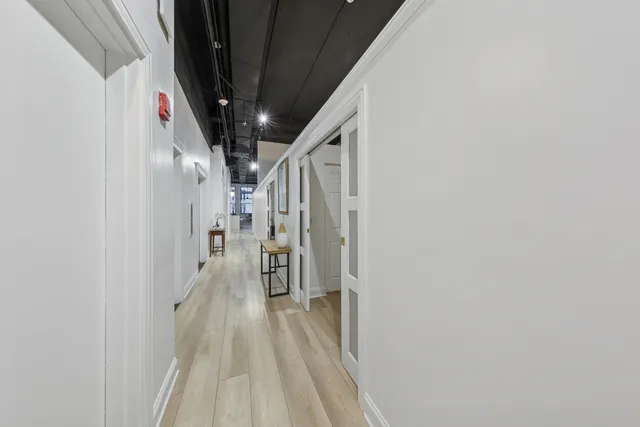 a living room with furniture large window and wooden floor