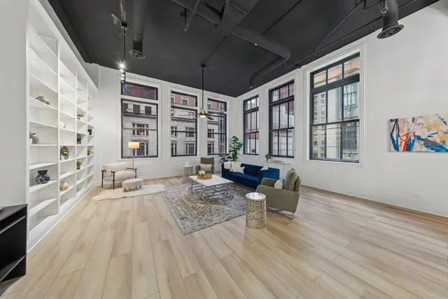 a living room with furniture large window and wooden floor
