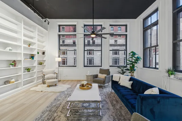 a large white kitchen with a stove a sink dishwasher and white cabinets with wooden floor