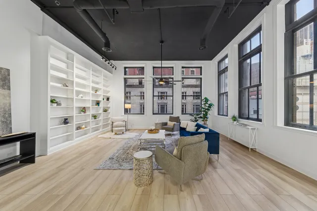 a large white kitchen with a large window a counter space and stainless steel appliances