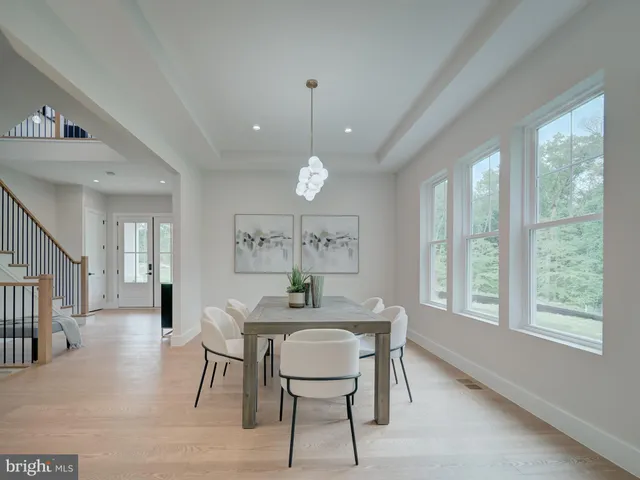 a large kitchen with stainless steel appliances granite countertop a stove a sink dishwasher and white cabinets with wooden floor