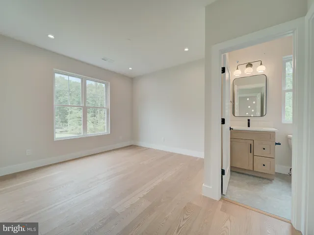 an empty room with windows and ceiling fan