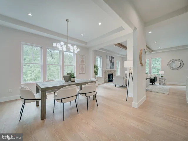 a dining room with wooden floor a chandelier a wooden table and chairs