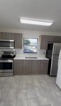 a kitchen with stainless steel appliances a stove a sink and a refrigerator