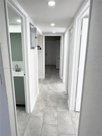 a view of entryway with white walls and open door