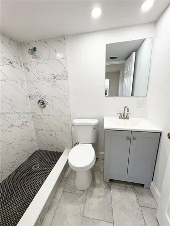a bathroom with a sink toilet and shower