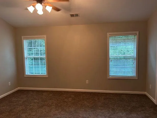 a white toilet sitting next to a white wall
