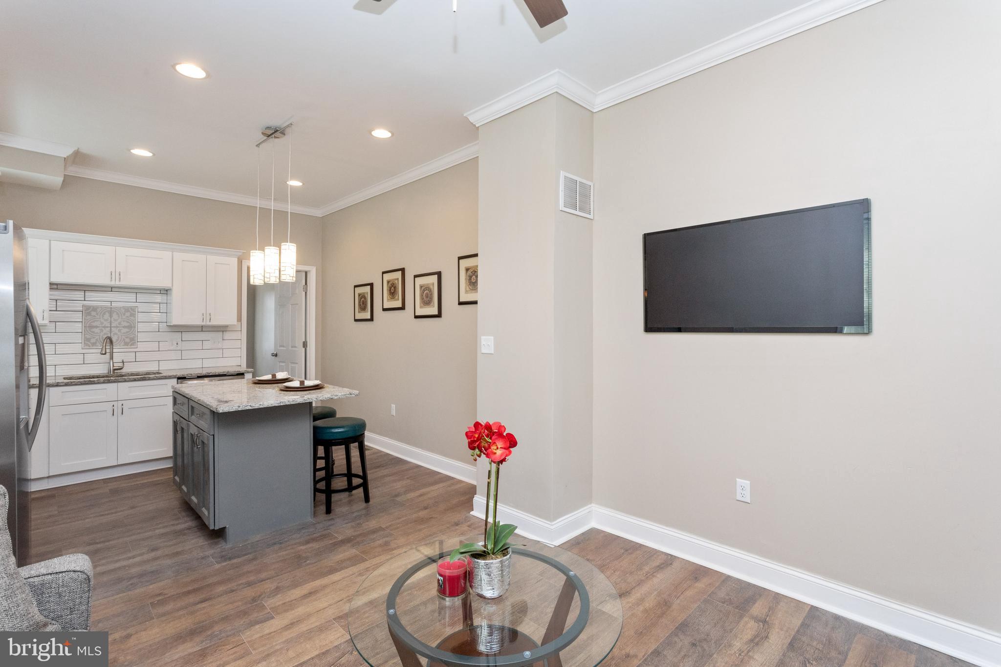 3988 Roland Avenue Baltimore, MD 21211 - Photo 11 of 31 a living room with stainless steel appliances kitchen island granite countertop furniture and a flat screen tv