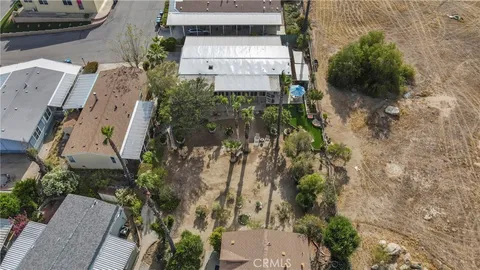 an aerial view of a house with a yard and large trees