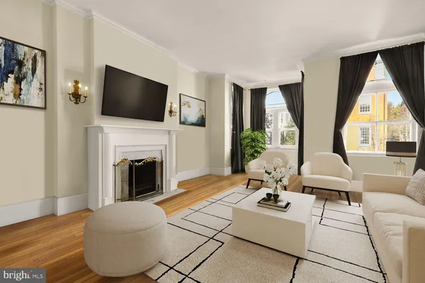 a living room with couches a flat screen tv and a fireplace